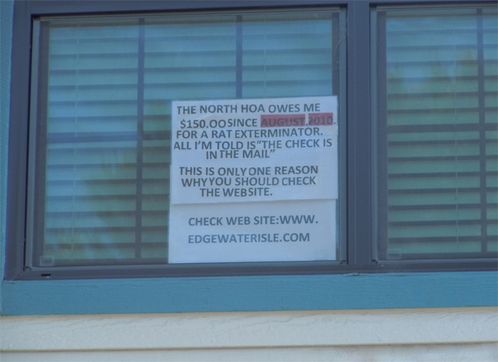 Edgewater Isle homeowner places sign in window to protest board's lack of response